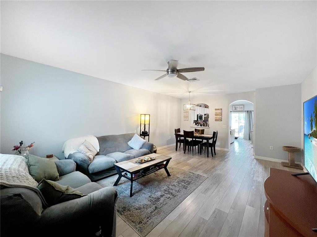 15767 Stable Run Drive Spring Hill, FL 34610 - Photo 5 of 34 a living room with furniture and a dining table with kitchen view