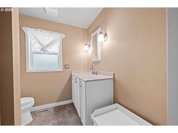 a bathroom with a toilet sink vanity and mirror