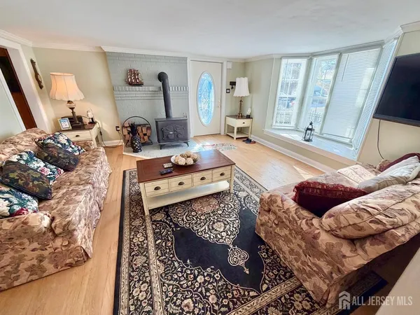 a kitchen with granite countertop a refrigerator a sink dishwasher a stove and white countertops with wooden floor