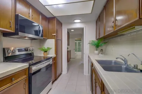 a kitchen with stainless steel appliances a sink a stove top oven a counter space and cabinets