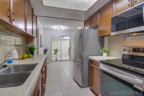 a kitchen with stainless steel appliances granite countertop a sink a refrigerator and a counter top
