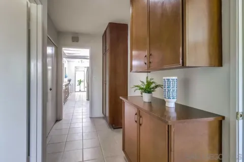 a hallway with a sink a refrigerator and a mirror