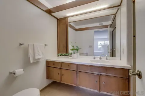 a bathroom with a sink and mirror with toilet
