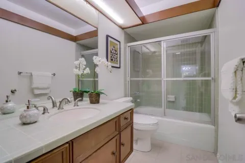 a bathroom with a granite countertop sink toilet and shower