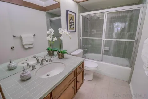 a bathroom with a granite countertop sink a toilet and shower