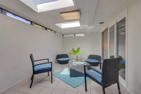 a dining room with furniture and a potted plant