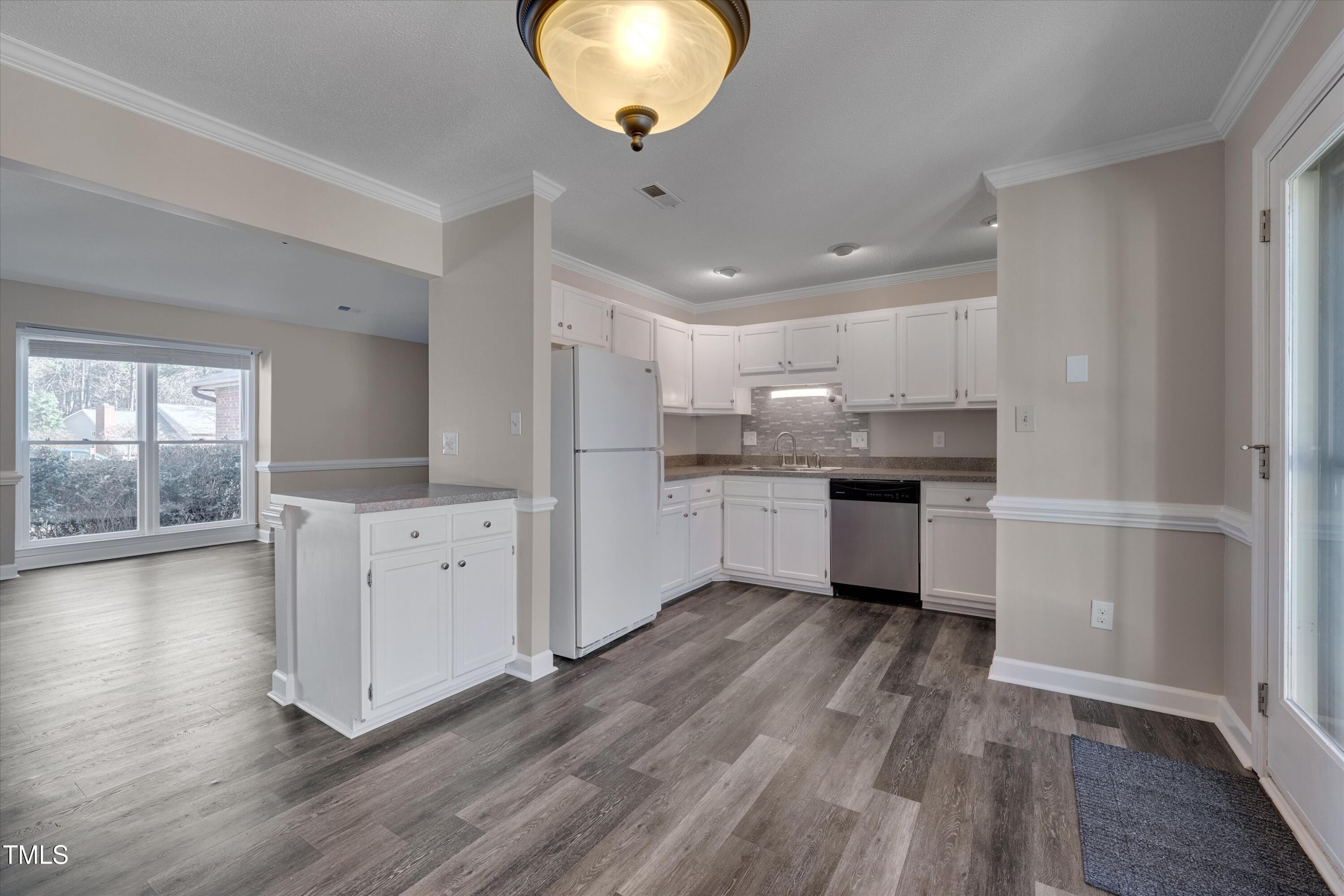 5500 Fortunes Ridge Drive, Unit 67B Durham, NC 27713 - Photo 13 of 34 a kitchen with stainless steel appliances granite countertop a refrigerator a sink dishwasher a stove and white cabinets with wooden floor