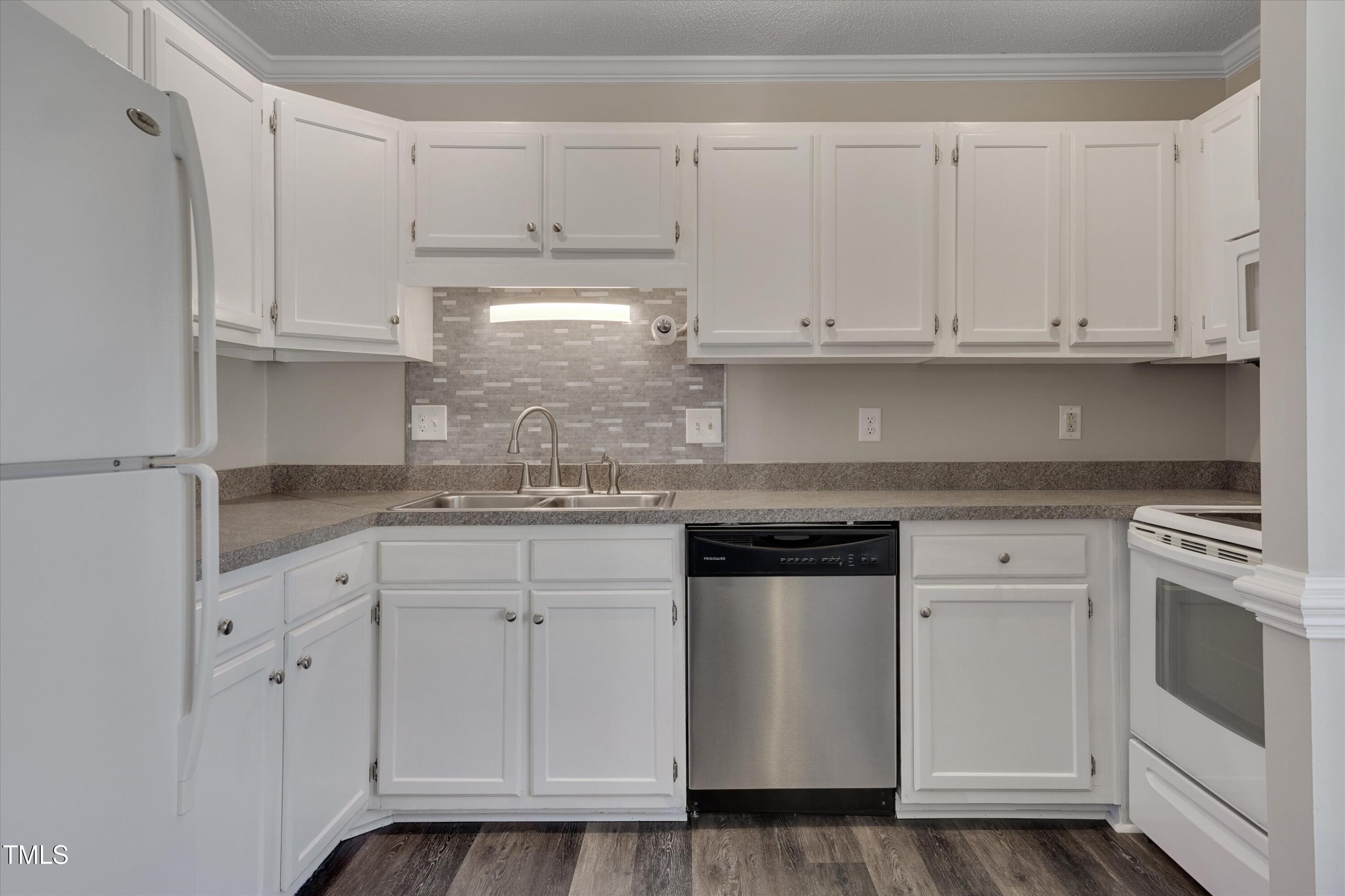 5500 Fortunes Ridge Drive, Unit 67B Durham, NC 27713 - Photo 15 of 34 a kitchen with granite countertop white cabinets and white appliances