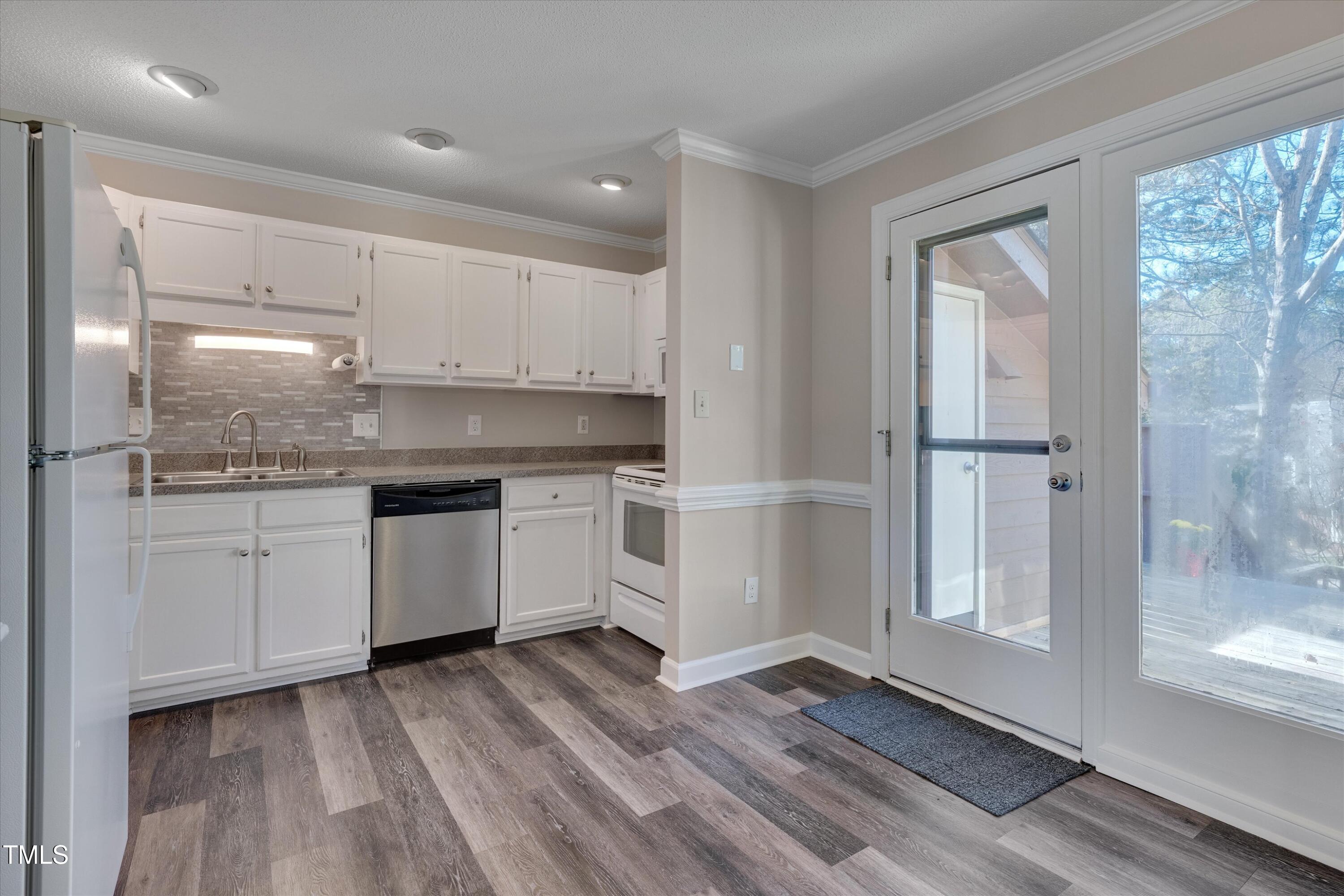 5500 Fortunes Ridge Drive, Unit 67B Durham, NC 27713 - Photo 16 of 34 a kitchen with a white cabinets and wooden floor