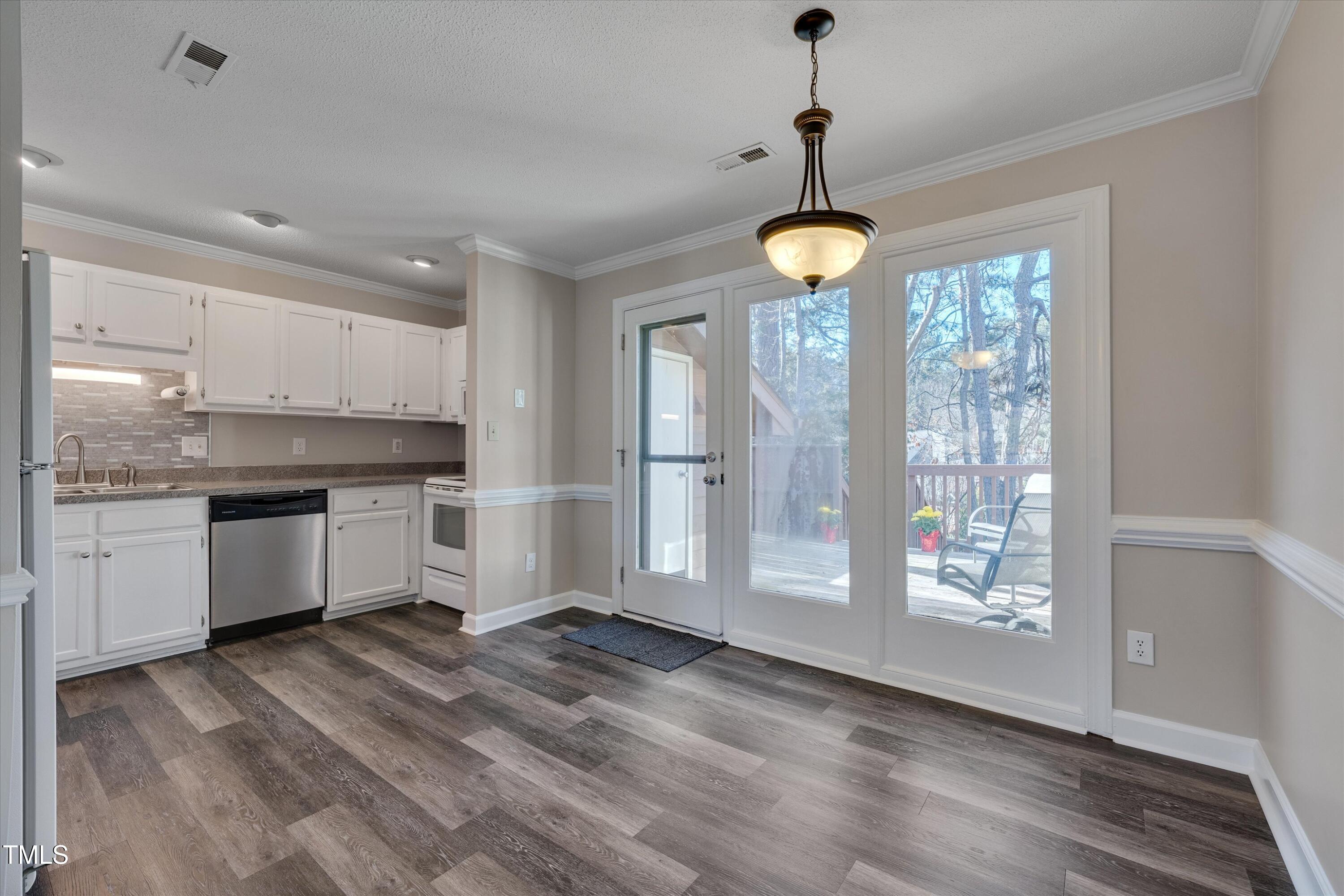5500 Fortunes Ridge Drive, Unit 67B Durham, NC 27713 - Photo 10 of 34 a kitchen with stainless steel appliances granite countertop a stove a sink dishwasher a refrigerator and white cabinets with wooden floor