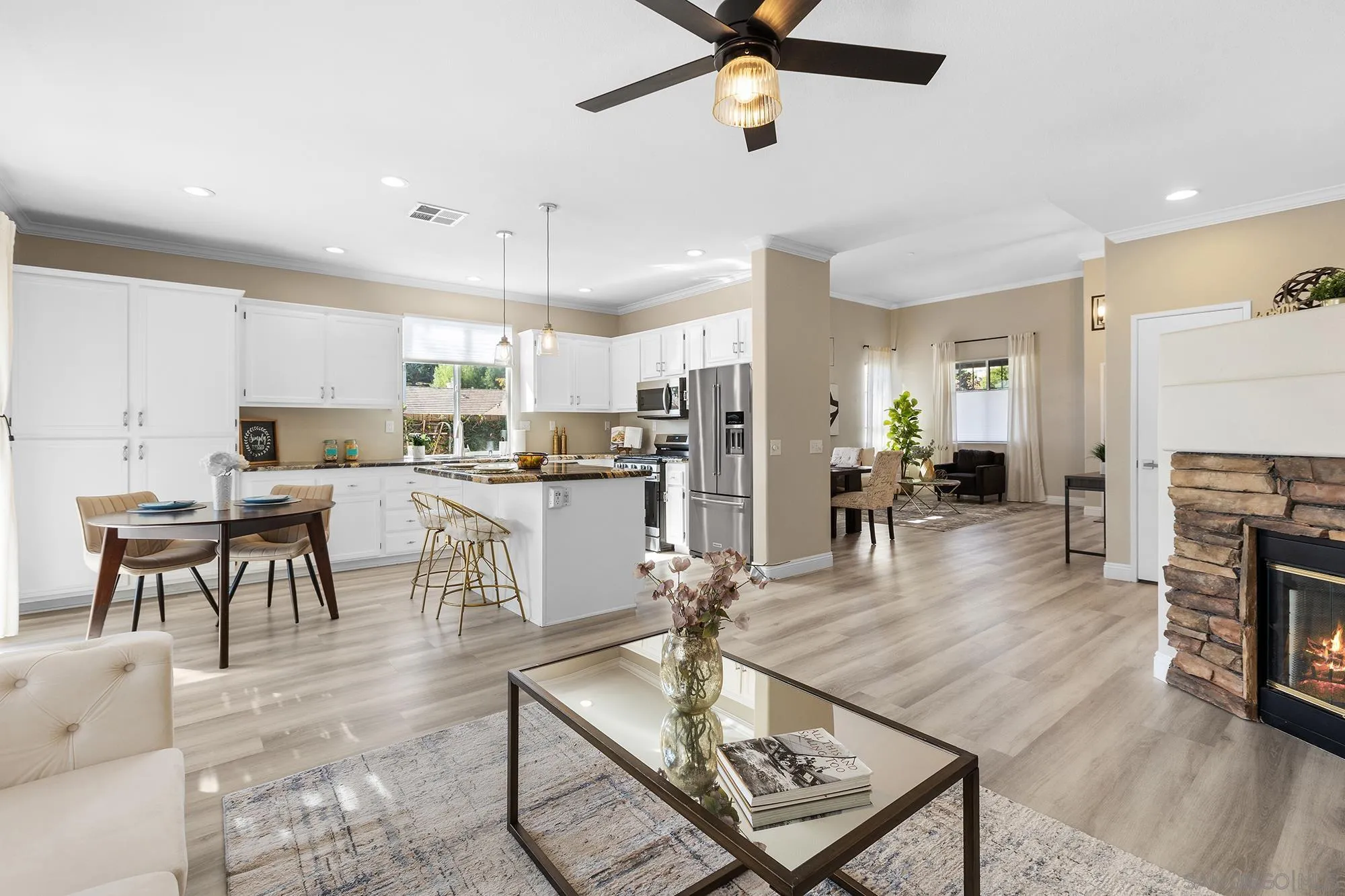33451 Victoria Court Temecula, CA 92592 - Photo 11 of 38 a kitchen with stainless steel appliances kitchen island granite countertop a refrigerator a stove a sink a dining table and chairs with wooden floor