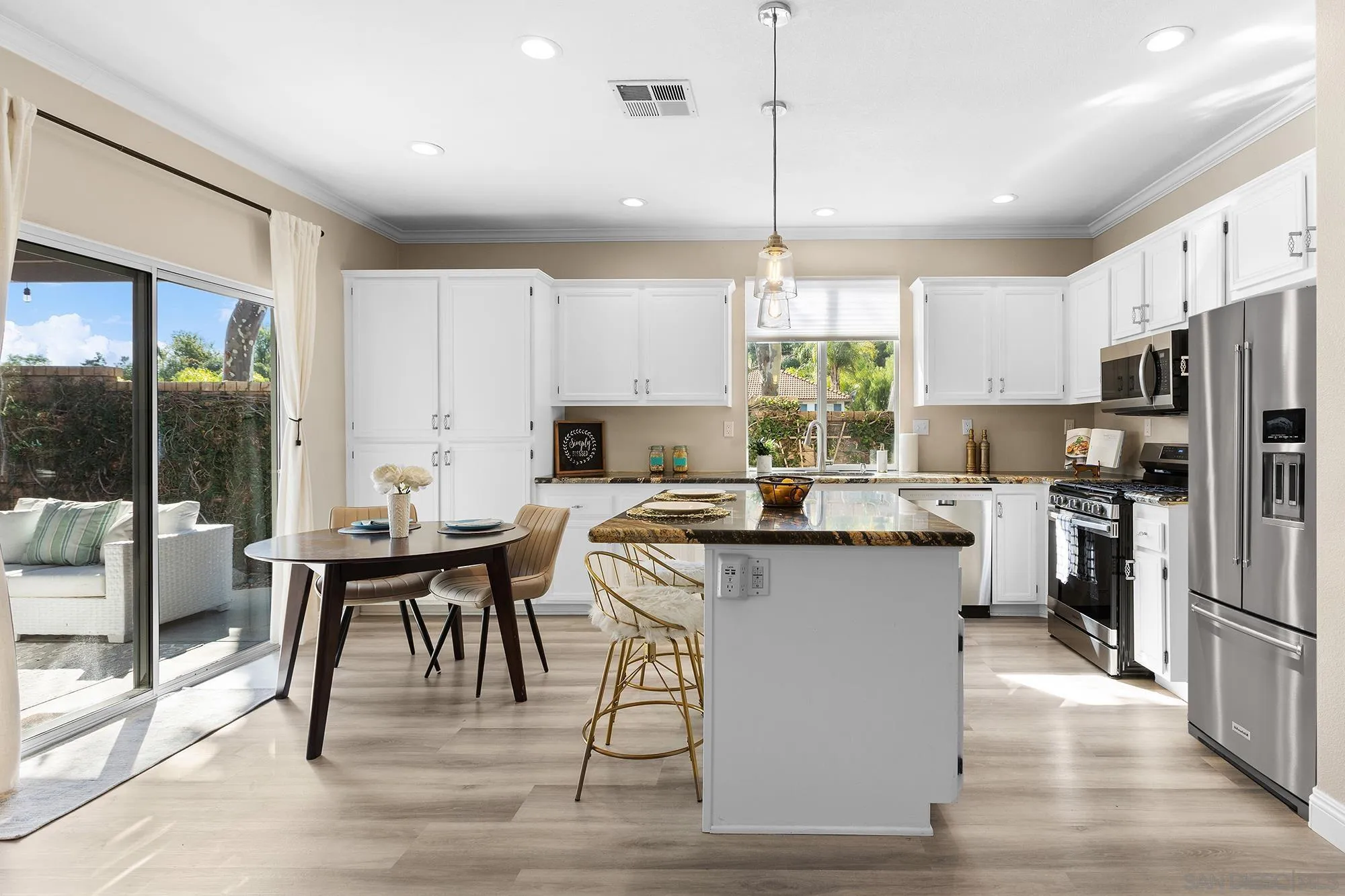 33451 Victoria Court Temecula, CA 92592 - Photo 14 of 38 a kitchen with stainless steel appliances granite countertop a table chairs refrigerator and wooden cabinets