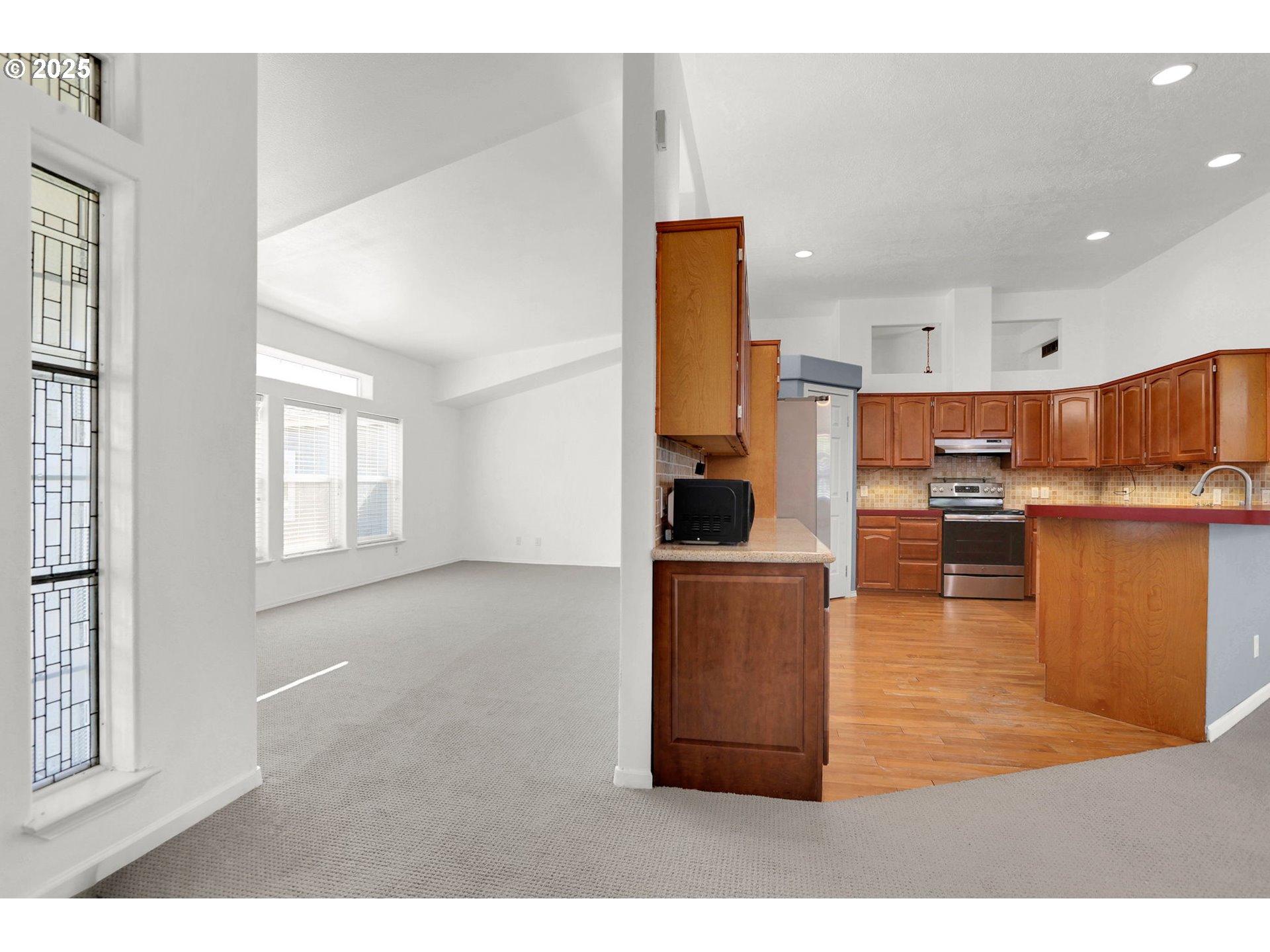 5365 Cobblestone Lane Eugene, OR 97402 - Photo 17 of 40 a kitchen with stainless steel appliances kitchen island granite countertop a refrigerator a stove and a sink with wooden floor