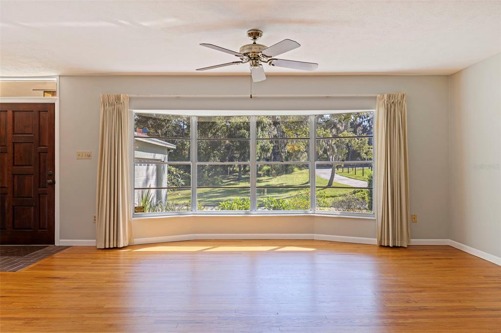 8609 Stoner Road Riverview, FL 33569 - Photo 17 of 66 a view of an empty room with wooden floor and a window