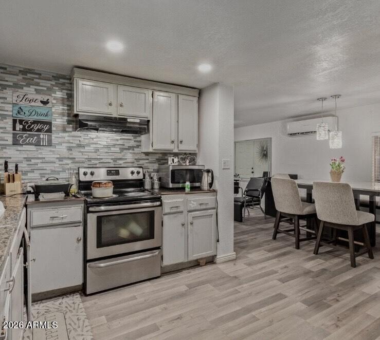 5002 West Bethany Home Road, Unit 104 Glendale, AZ 85301 - Photo 4 of 17 a kitchen with stainless steel appliances a stove a sink dishwasher a microwave oven with cabinets and wooden floor