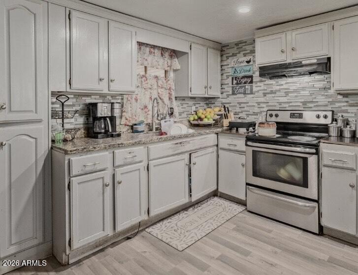 5002 West Bethany Home Road, Unit 104 Glendale, AZ 85301 - Photo 6 of 17 a kitchen with stainless steel appliances granite countertop a stove a sink and white cabinets