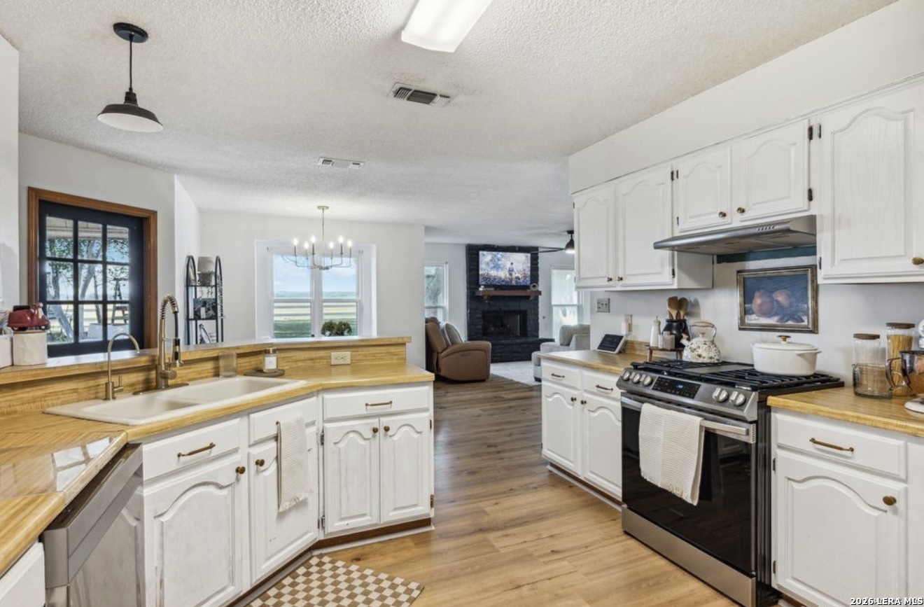 101 Country Castroville, TX 78009 - Photo 5 of 14 a kitchen with stainless steel appliances granite countertop a sink stove and cabinets