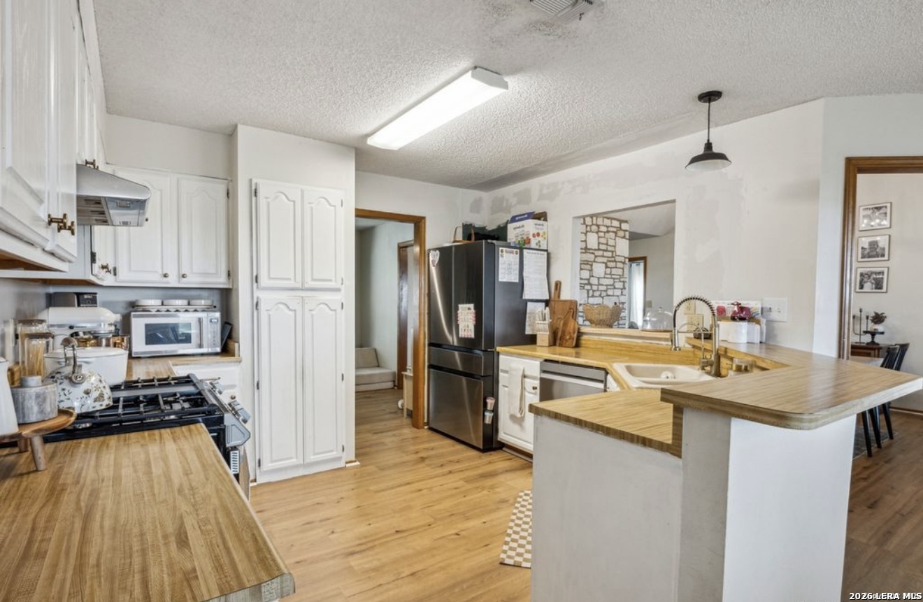 101 Country Castroville, TX 78009 - Photo 6 of 14 a kitchen with stainless steel appliances granite countertop a sink stove and refrigerator