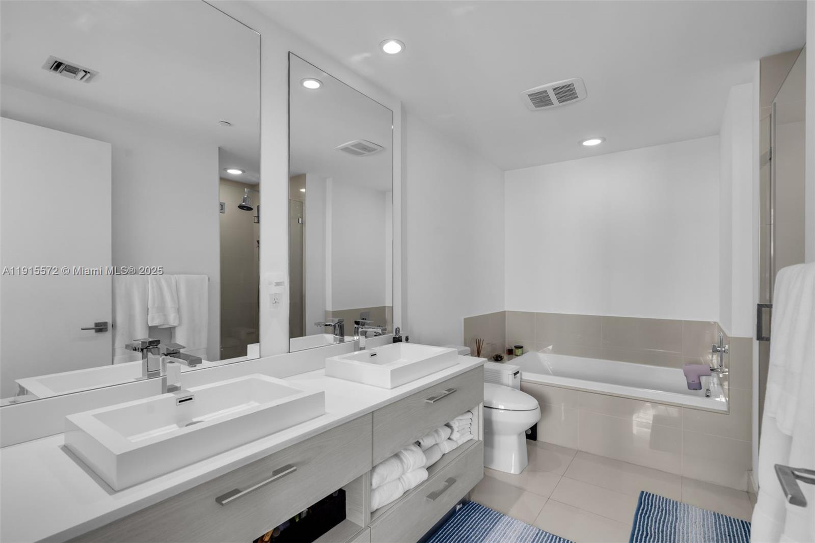 55 Southwest 9th Street, Unit 4008 Miami, FL 33130 - Photo 11 of 36 a bathroom with a double vanity sink mirror and toilet