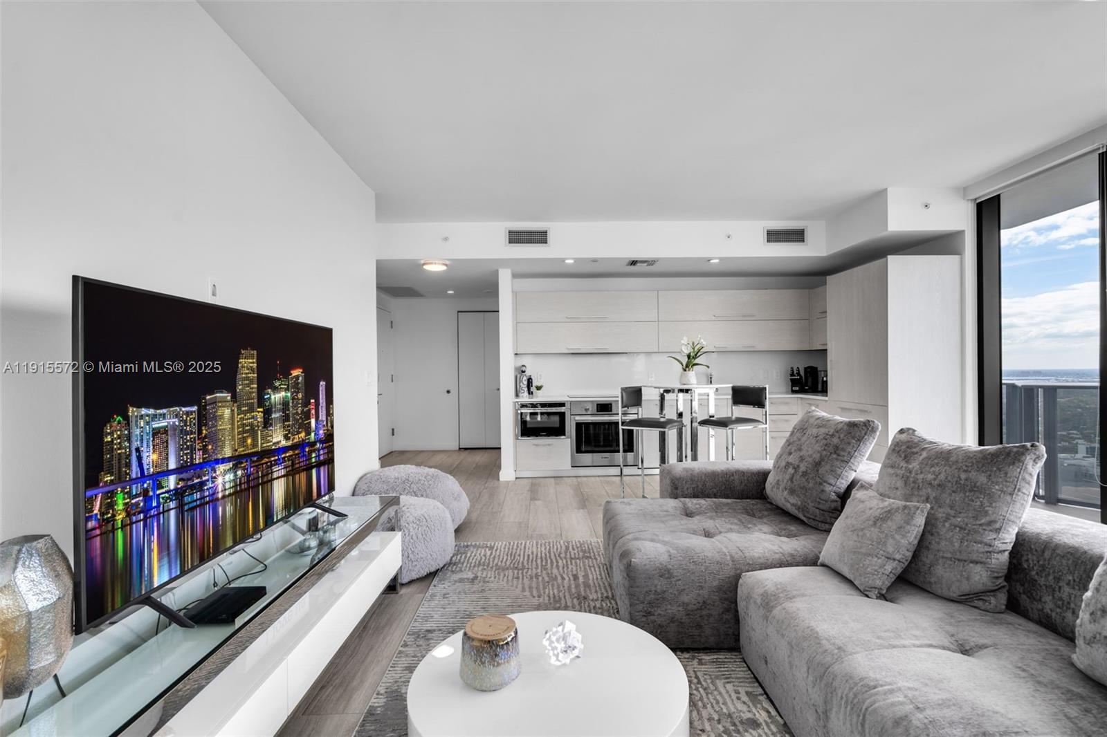 55 Southwest 9th Street, Unit 4008 Miami, FL 33130 - Photo 6 of 36 a living room with furniture and a book shelf
