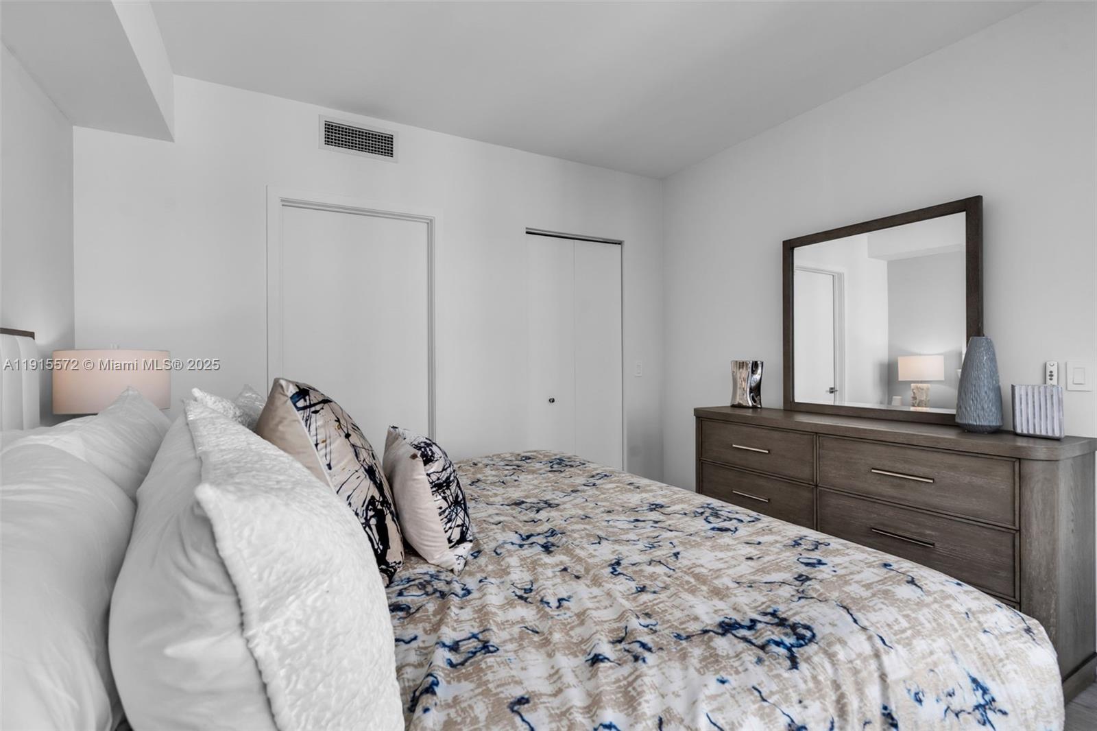 55 Southwest 9th Street, Unit 4008 Miami, FL 33130 - Photo 10 of 36 a bedroom with a bed and a large mirror