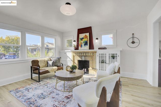 a living room with furniture a fireplace and large windows