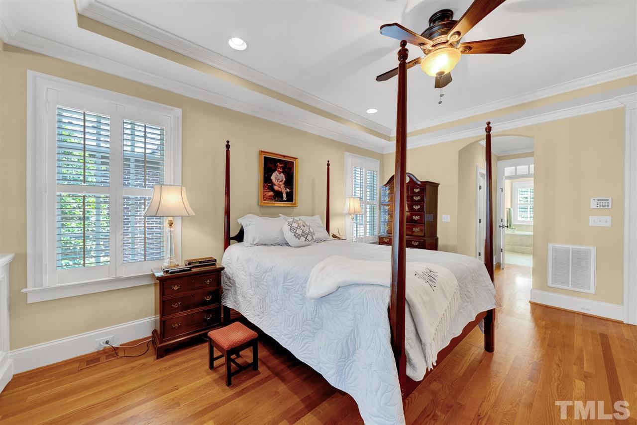 403 Yarmouth Road Raleigh, NC 27608 - Photo 16 of 30 a bedroom with a bed and a chandelier