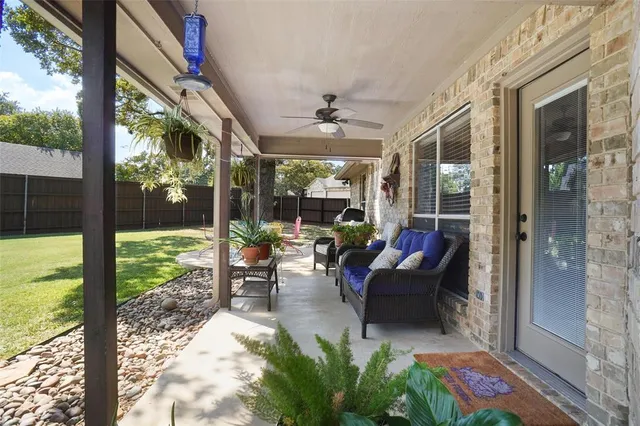 a living room with patio furniture and garden view