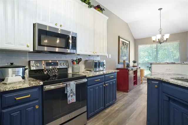 a kitchen with stainless steel appliances granite countertop a sink stove and microwave