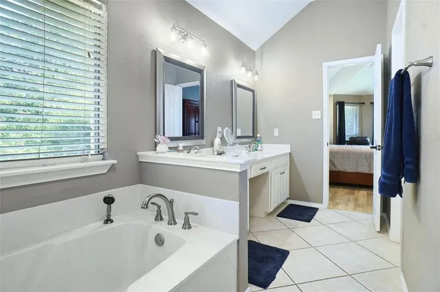 a bathroom with a sink a tub and a mirror