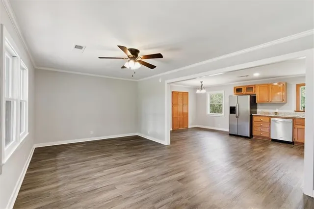 a view of a big room with wooden floor and a kitchen