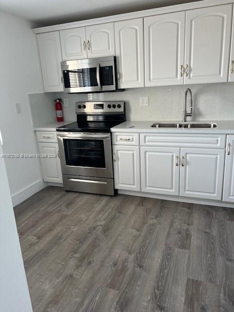 a kitchen with stainless steel appliances a white stove top oven and sink