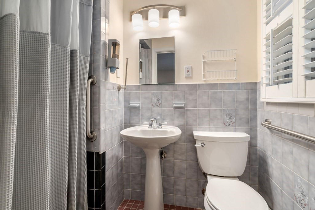 83 Pine Street Natick, MA 01760 - Photo 12 of 28 a bathroom with a toilet sink and mirror