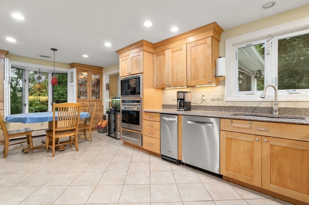 83 Pine Street Natick, MA 01760 - Photo 4 of 28 a kitchen with stainless steel appliances granite countertop a stove a sink and a microwave