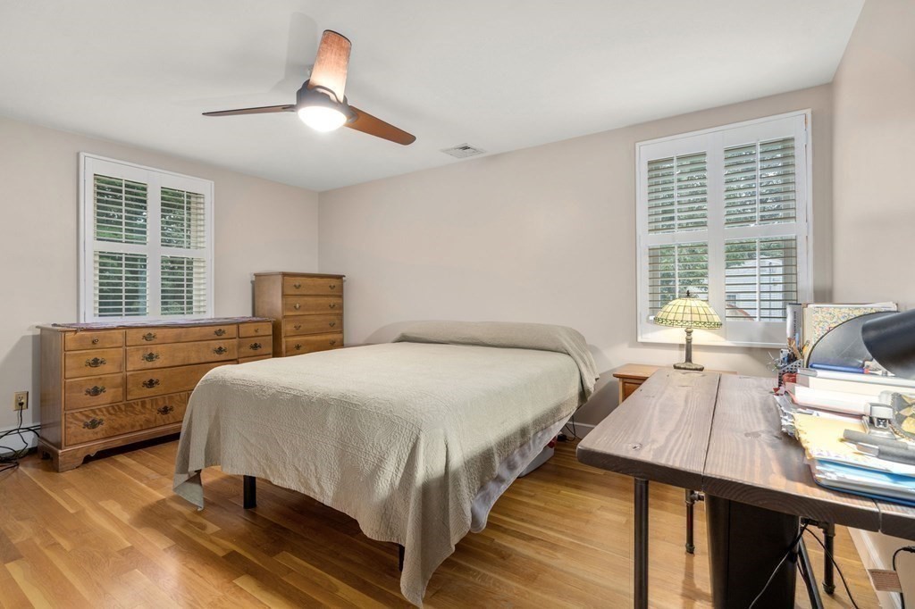 83 Pine Street Natick, MA 01760 - Photo 10 of 28 a bedroom with a bed and wooden floor