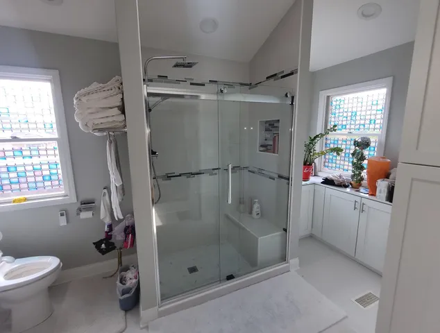 a bathroom with a shower toilet and sink