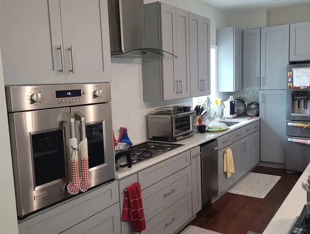 a kitchen with stainless steel appliances a stove a sink and cabinets