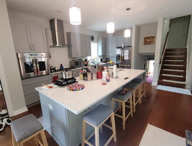 a kitchen with a dining table chairs and white cabinets