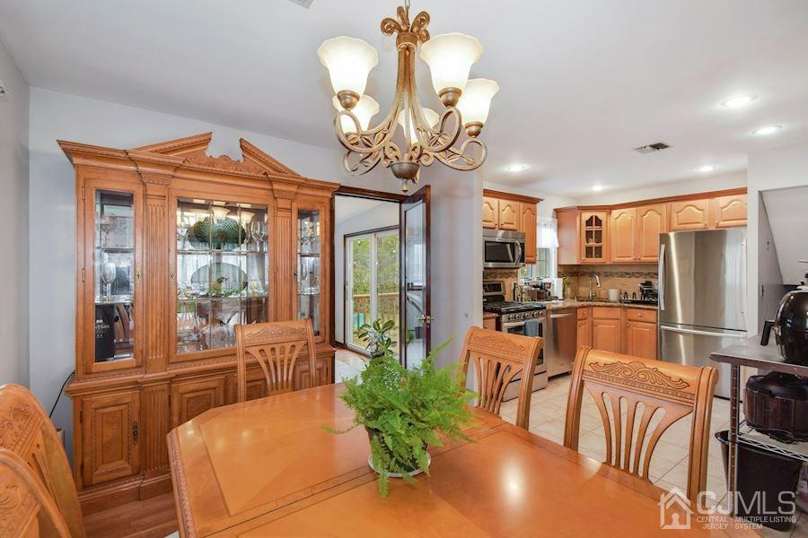 4 Finley Road Edison, NJ 08817 - Photo 8 of 32 a view of a dining room with furniture large windows chandeliers and a chandelier