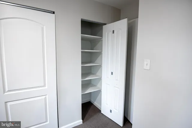 a view of walk in closet with empty racks