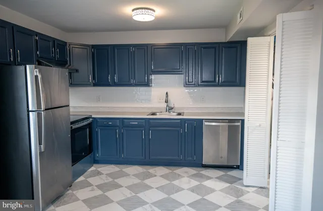 a kitchen with a refrigerator sink and cabinets