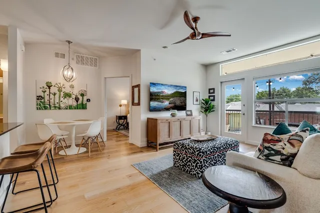 a living room with furniture a flat screen tv and a large window