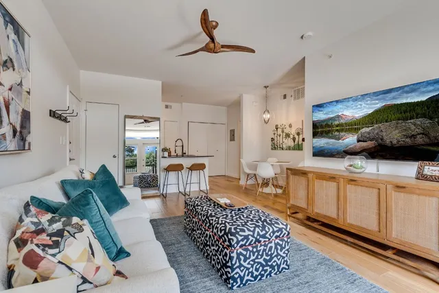 a living room with furniture a rug and kitchen view