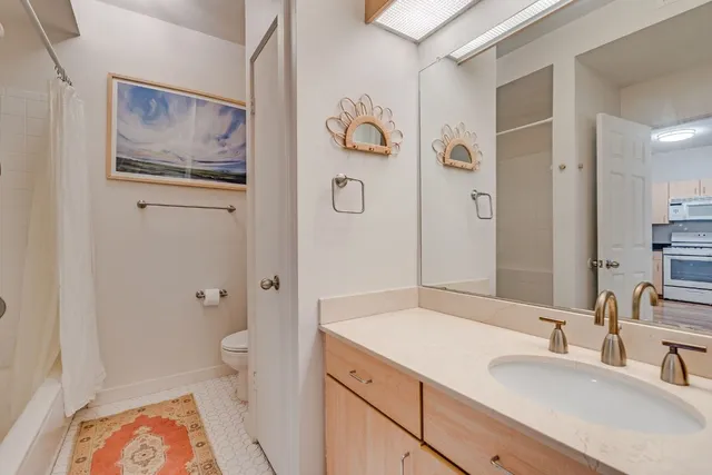 a bathroom with a granite countertop sink a toilet and shower
