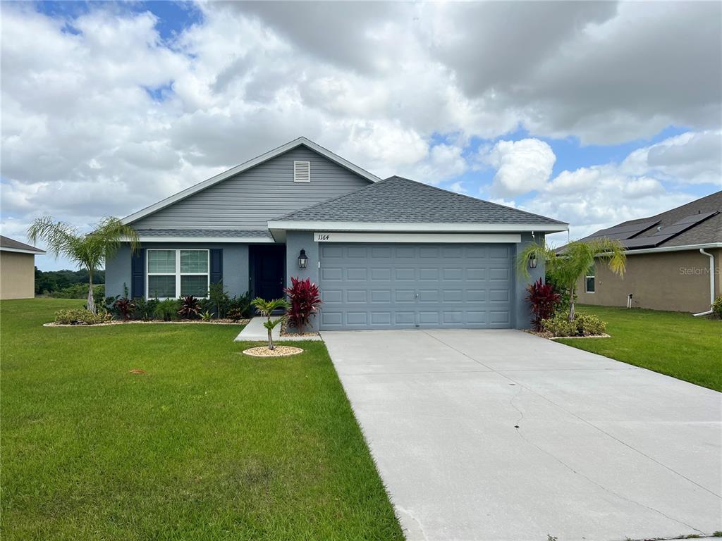 1164 Legatto Loop Dundee, FL 33838 - Photo 1 of 1 a front view of house with yard and green space