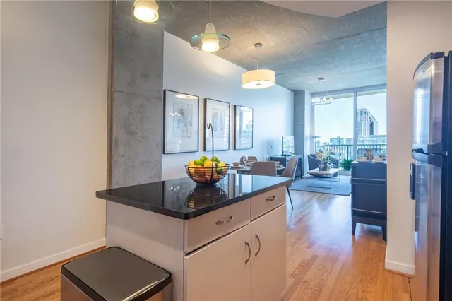 a kitchen with stainless steel appliances granite countertop a sink counter space and living room view