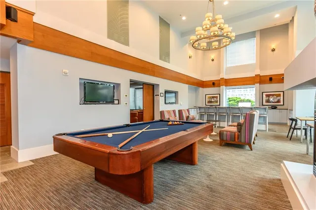 a living room with furniture a large window and wooden floor