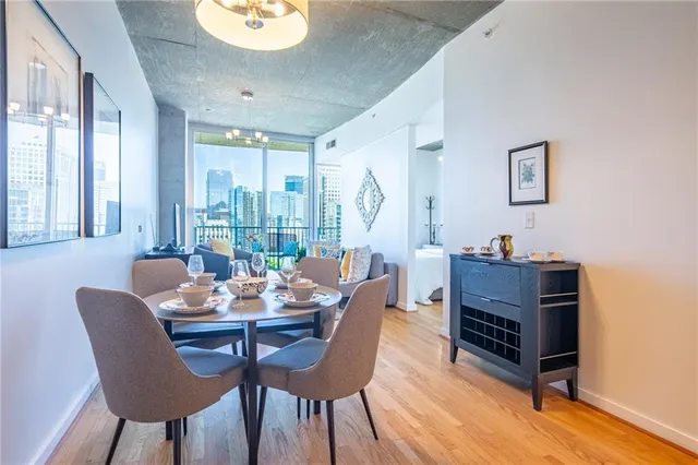 a dining room with furniture a chandelier and wooden floor