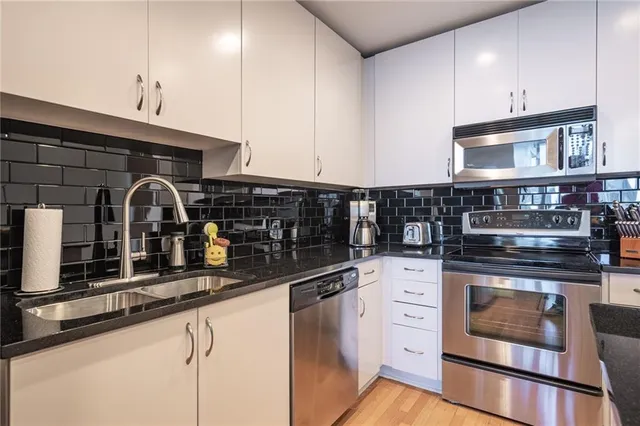 a kitchen with appliances a sink and cabinets