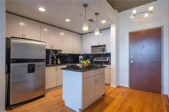 a kitchen with kitchen island a sink stainless steel appliances and counter space